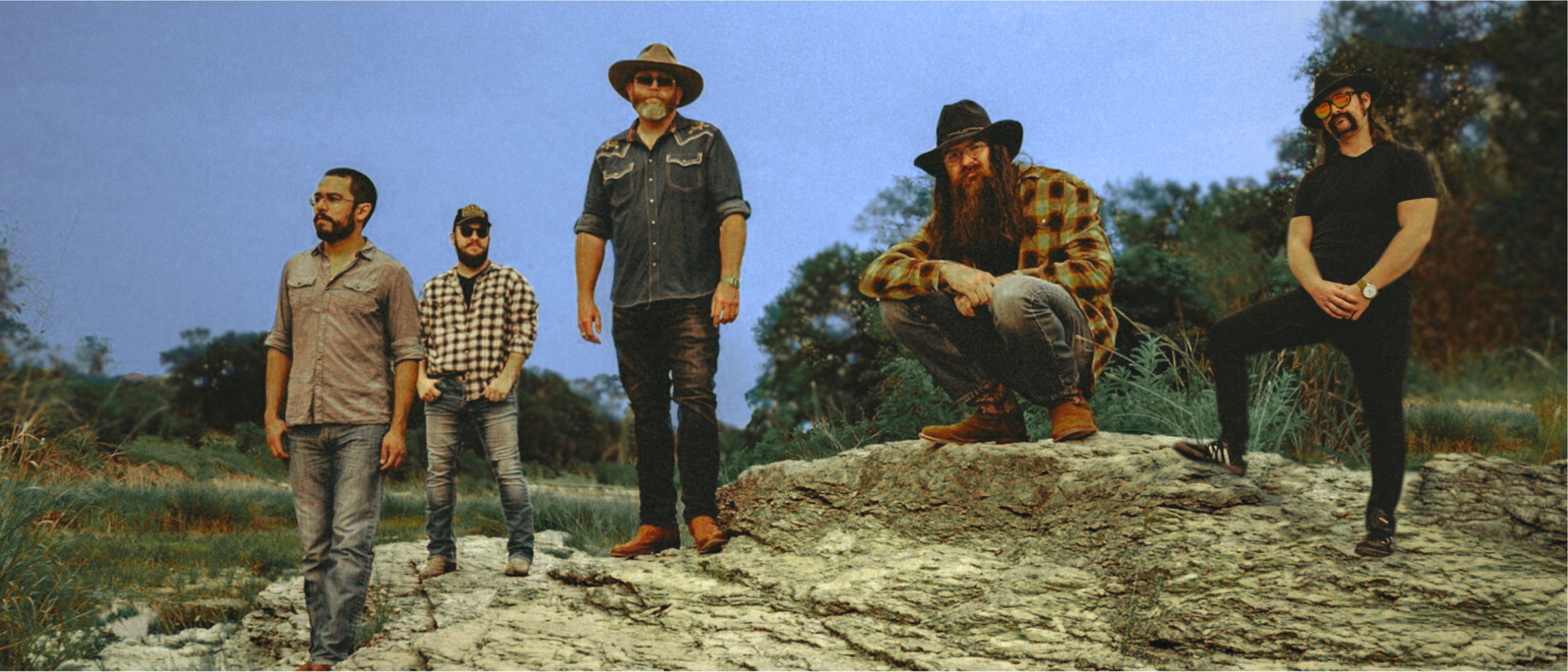 The band standing on uneven rocks